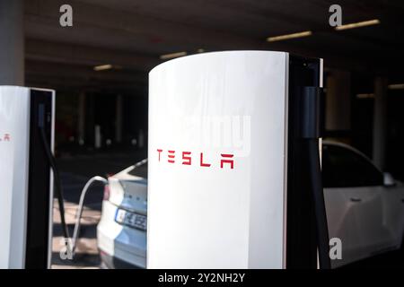 Capodistria, Slovenia - 25 agosto 2024: Una Tesla Model Y si ricarica presso una stazione V4 Supercharger, che offre la più recente tecnologia di ricarica rapida per i veicoli elettrici. La stazione di ricarica Tesla simboleggia il progresso nell'elettromobilità e la transizione verso l'energia sostenibile nel trasporto su strada *** Ein Tesla Model Y lädt una stazione di ricarica einer V4, Die Modernste Schnelllade-Technologie für Elektrofahrzeuge bietet. Die Tesla-Ladestation symbolisiert den Fortschritt in der Elektromobilität und den Wandel zu nachhaltiger energie im Straßenverkehr Foto Stock