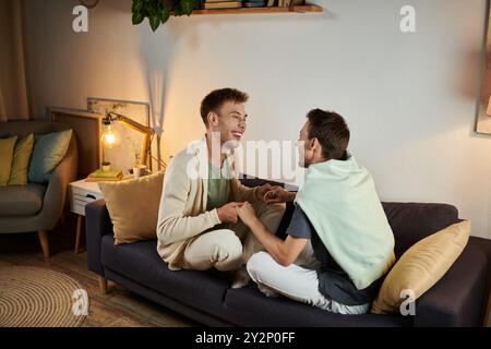 Coppia amorevole che si diverte mentre si siede su un comodo divano. Foto Stock