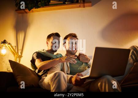 Una coppia allegra condivide un momento di spensieratezza mentre si è impegnati con un notebook. Foto Stock