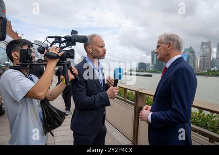 Shanghai, Cina 20240911. Il primo ministro norvegese Jonas Gahr Store riassume il suo viaggio di tre giorni in Cina al giornalista della NRK Philip Lote e al fotografo Fang. Sullo sfondo si può vedere il famoso skyline che caratterizza l'intera città. Foto: Heiko Junge / NTB Foto Stock