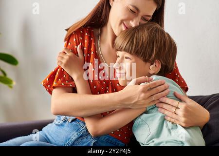 Un momento amorevole tra una madre e il suo bambino con problemi di udito pieno di gioia. Foto Stock