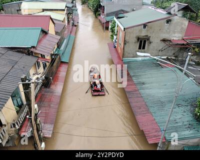 Hanoi, Vietnam. 10 settembre 2024. Membri del team di soccorso barche a remi per trasferire le persone intrappolate nella provincia di Yen Bai, Vietnam, 10 settembre 2024. A partire da mercoledì mattina, il tifone Yagi e le conseguenti frane e inondazioni avevano lasciato 141 morti e 59 dispersi nella regione settentrionale del Vietnam, ha annunciato il Ministero dell'Agricoltura e dello sviluppo rurale. Crediti: VNA/Xinhua/Alamy Live News Foto Stock