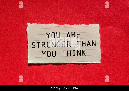 Sei più forte di quanto pensi messaggio scritto su un pezzo di carta strappato su sfondo rosso. Concettuale sei più forte di quanto pensi, simbolo. Copia Foto Stock