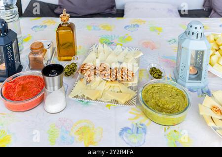 Una vasta gamma di cibi salutari disposti per i partecipanti in un ritiro, con fette di formaggio, noci, guacamole, anguria, e una salsa a base di pomodoro. Foto Stock