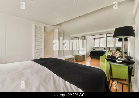 Questa immagine mostra una camera da letto moderna con interni eleganti, con un comodo letto, arredi eleganti e molta luce naturale. Foto Stock
