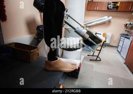 Immagine di una gamba protesica in un'officina, che mostra il processo di produzione e gli strumenti utilizzati nella produzione di protesi. Foto Stock