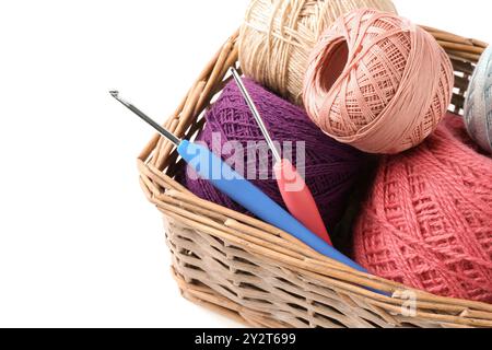 Molti filati colorati e ganci a uncinetto in cestello di vimini isolato su bianco Foto Stock