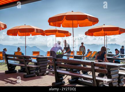 Ombrelloni arancioni sulla terrazza dell'Hochzelleralm sopra Zell am SEE con vista sul Leonganger Steinberge nella regione Pinzgau a Salisburgo, Au Foto Stock