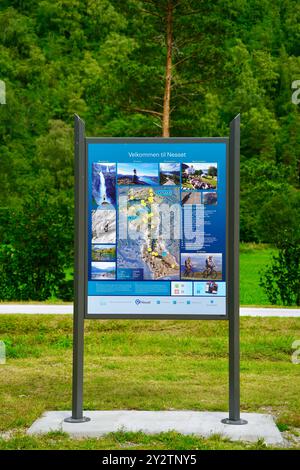 Bacheca informativa che accoglie i visitatori a Nesset con uno sfondo di lussureggiante foresta verde. Foto Stock