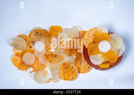 Vista dall'alto di un piccolo misto di Masala e Plane dal e Sabudana Papad sparso sulla superficie bianca da un Kunke o da un vaso di canna, immagine da confezionare Foto Stock