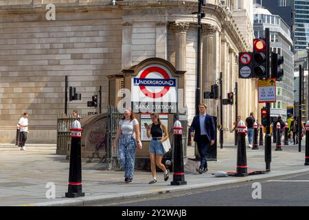 Persone che camminano oltre l'ingresso di Princes Street alla stazione della metropolitana Bank presso Bank Junction nella City di Londra, Londra, Regno Unito Foto Stock