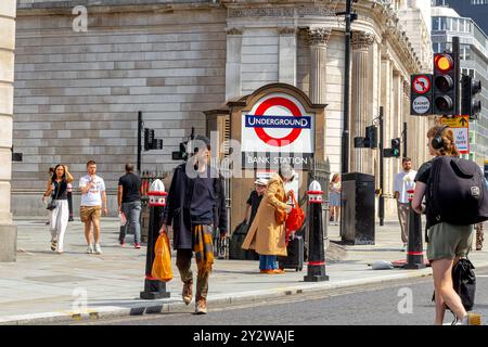 Un uomo che attraversa la strada a Bank Junction vicino all'ingresso di Princes Street alla stazione della metropolitana Bank nella City di Londra, Londra, Regno Unito Foto Stock