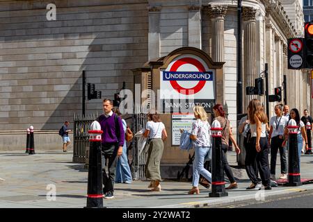 Persone che camminano oltre l'ingresso di Princes Street alla stazione della metropolitana Bank presso Bank Junction nella City di Londra, Londra, Regno Unito Foto Stock