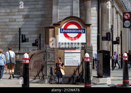 Una donna che esce dall'entrata di Princes Street alla stazione della metropolitana Bank presso Bank Junction nella City di Londra, Londra, Regno Unito Foto Stock