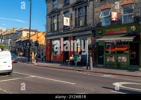 Due persone sedute fuori dal Northcote, un pub in Clapham Junction all'angolo tra Battersea Rise e Northcote Road, London SW11 Foto Stock