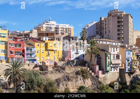 Una vista panoramica di edifici colorati su una collina nella storica città di Villajoyosa, in Spagna, sotto un cielo azzurro. Foto Stock