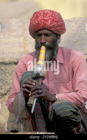 Un incantatore di serpenti suona musica di fronte al serpente cobra nella città di Jaisalmer, nella provincia del Rajasthan in India. India, Jaisalmer, gennaio 1998 Foto Stock