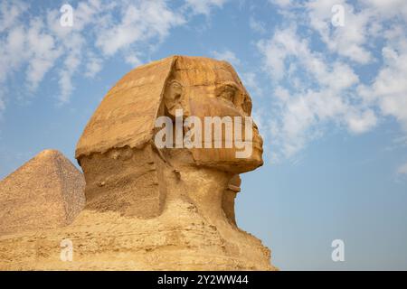 Splendido profilo della grande Sfinge, con piramidi di Menkaure e Khafre sullo sfondo in una giornata limpida e soleggiata con cielo blu a Giza, il Cairo, in Egitto Foto Stock