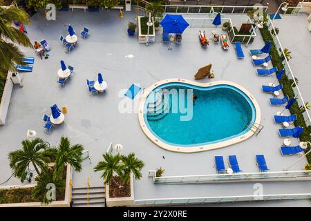 Vista dall'alto dei giardini dell'hotel con piscina all'aperto, lettini, ombrelloni e persone che nuotano. Miami Beach. STATI UNITI. Foto Stock