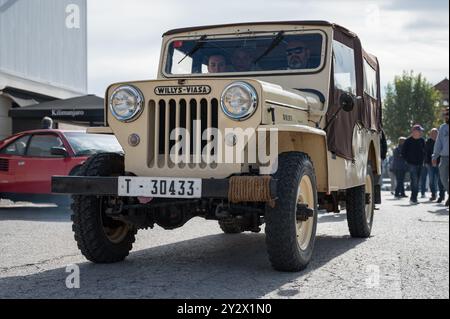 Storica jeep militare americana fuoristrada Willys Viasa CJ3-B di colore terra. Ha una fune legata al paraurti e un tetto in tela marrone. Foto Stock