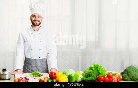 Chef Maschile In Uniforme Sorridente In Piedi In Cucina Foto Stock