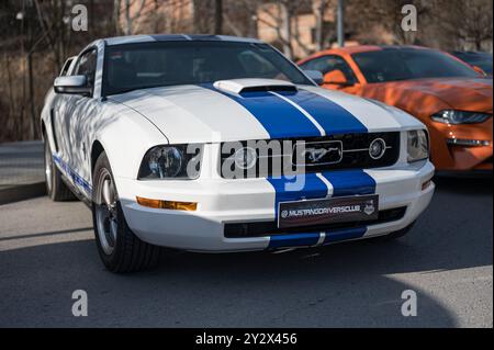 Vista frontale di una vettura sportiva americana Ford Mustang di quinta generazione, bianca con strisce blu Foto Stock