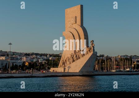 Il Monumento delle scoperte è una delle attrazioni turistiche più popolari di Lisbona. Situato a Belém, nella parte occidentale della città, celebra le conquiste di Vasco da Gama e di altri esploratori portoghesi del passato. L'imponente scultura in pietra che assomiglia a una nave storica fu eretta direttamente sulle rive del fiume Tejo, dove passavano tutte le navi che entravano nel porto di Lisbona. Foto Stock