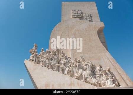 Il Monumento delle scoperte è una delle attrazioni turistiche più popolari di Lisbona. Situato a Belém, nella parte occidentale della città, celebra le conquiste di Vasco da Gama e di altri esploratori portoghesi del passato. L'imponente scultura in pietra che assomiglia a una nave storica fu eretta direttamente sulle rive del fiume Tejo, dove passavano tutte le navi che entravano nel porto di Lisbona. Foto Stock