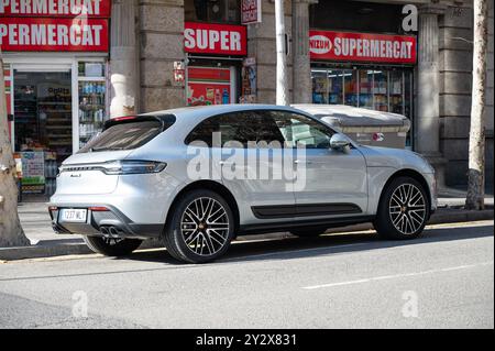 Vista posteriore di un moderno SUV di lusso parcheggiato male sulla strada della città di Barcellona, è una Porsche Macan S argentata Foto Stock