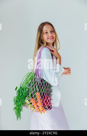 Donna che tiene in mano un sacchetto con verdure fresche, carote, ravanelli, Foto Stock