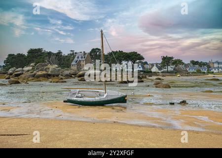 Tregastel nel nord della Bretagna, spiaggia con bassa marea, nelle Cotes d'Armorcon una barca a vela Foto Stock