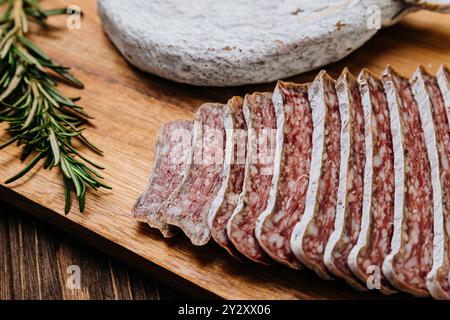 Primo piano di salame salato a fette a bordo, ideale per piatti gourmet e presentazioni di salumi Foto Stock