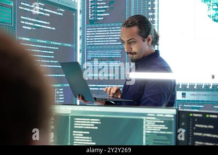 Hacker governativi che monitorano gli attacchi informatici su un grande schermo, compromettendo la sicurezza online. Specialista infiltrato nelle reti digitali, violando i protocolli di sicurezza. Attività di Cyber-sorveglianza. Foto Stock