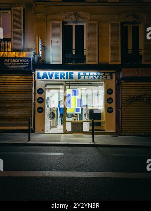Parigi - 2 settembre 2024 - lavanderia automatica di notte nella buia sera via vuota di Parigi Foto Stock