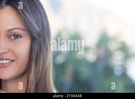 Sul balcone, una giovane donna sorridente dalla pelle limpida che si gode una rilassante giornata in spa all'aperto, spazio per fotocopie Foto Stock