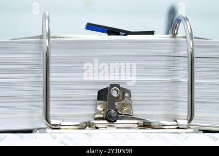 Primo piano di un file metallico di cartelle cartacee mantenendo automatico l'ufficio di oggetti concettuali di varie aziende Foto Stock