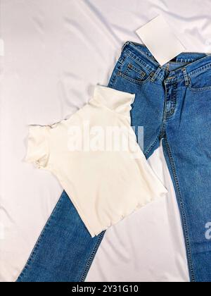 Camicia a righe bianche, blu jean isolato su sfondo grigio vista dall'alto. Lo stile di outfit da donna quotidiano e fresco. Foto Stock