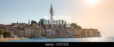 Mentre il sole tramonta su Rovigno, il caldo bagliore illumina la pittoresca cittadina costiera, evidenziando le vivaci sfumature della sua architettura storica e di circa Foto Stock