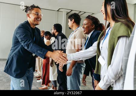Gruppo di professionisti che stringono la mano e creano contatti in un ambiente d'ufficio, creando connessioni e costruendo relazioni. Foto Stock