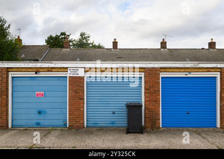 Garage con porte dipinte di blu in un blocco di garage vicino a Saint Michael's Road, Basingstoke, Hampshire, Regno Unito. 11 settembre 2023 Foto Stock