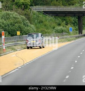 Auto nella zona di rifugio di emergenza gialla con telefono in layby sull'autostrada M4 smart dove la spalla rigida è diventata una corsia di traffico extra Inghilterra Regno Unito Foto Stock