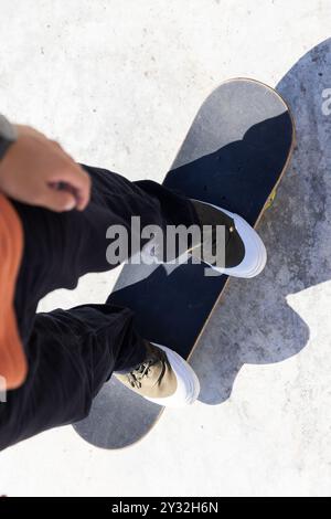 In equilibrio su skateboard all'aperto, skateboard adolescente asiatico con scarpe casual Foto Stock