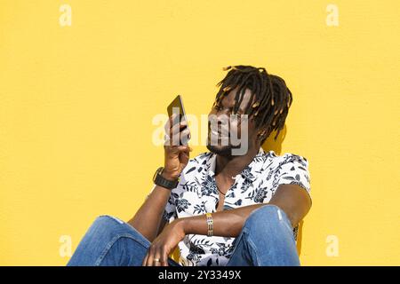 uomo nero sorridente che registra un messaggio vocale Foto Stock