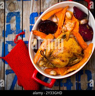 Il pollo cotto con raccolti di radice. vista dall'alto. messa a fuoco selettiva. Foto Stock