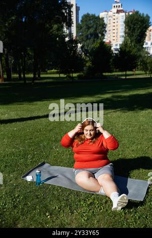 Una donna di grandi dimensioni si esercita all'aperto, abbracciando la natura e il fitness. Foto Stock