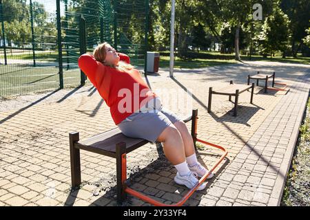 Una donna di grandi dimensioni si esercita all'aperto in una giornata intensa. Foto Stock