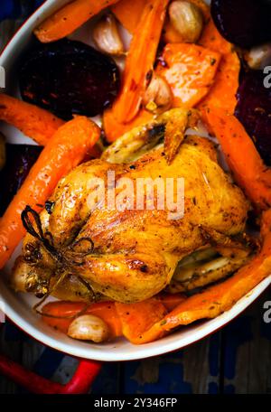 Il pollo cotto con raccolti di radice. vista dall'alto. messa a fuoco selettiva. Foto Stock