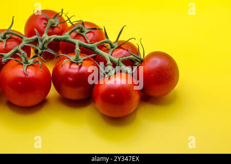Pomodoro rosso con gambo isolato su sfondo giallo Foto Stock