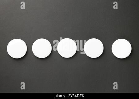 Logo dei pulsanti bianchi vuoti su sfondo nero, vista dall'alto. Mockup per il design Foto Stock