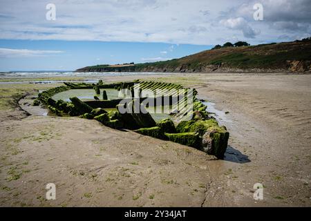 Resti di un naufragio sulla spiaggia dell'insenatura di Kervijen durante la bassa marea. Foto Stock